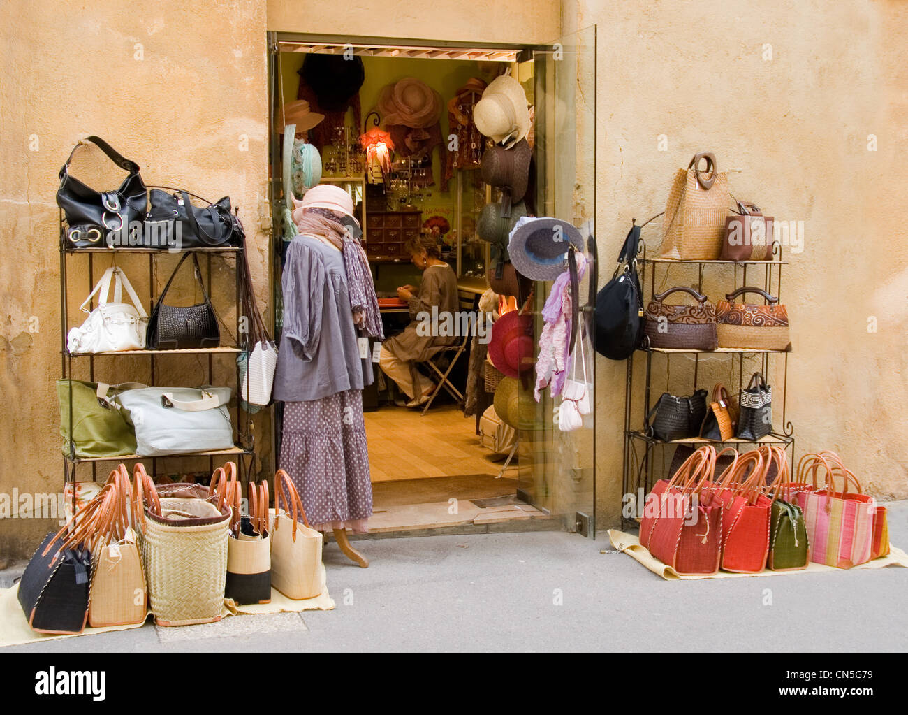 Affichage de la chaussée à un chapeau et sac à main shop à Aix en Provence,  France, montrant le propriétaire travaillant à travers les portes ouvertes  Photo Stock - Alamy