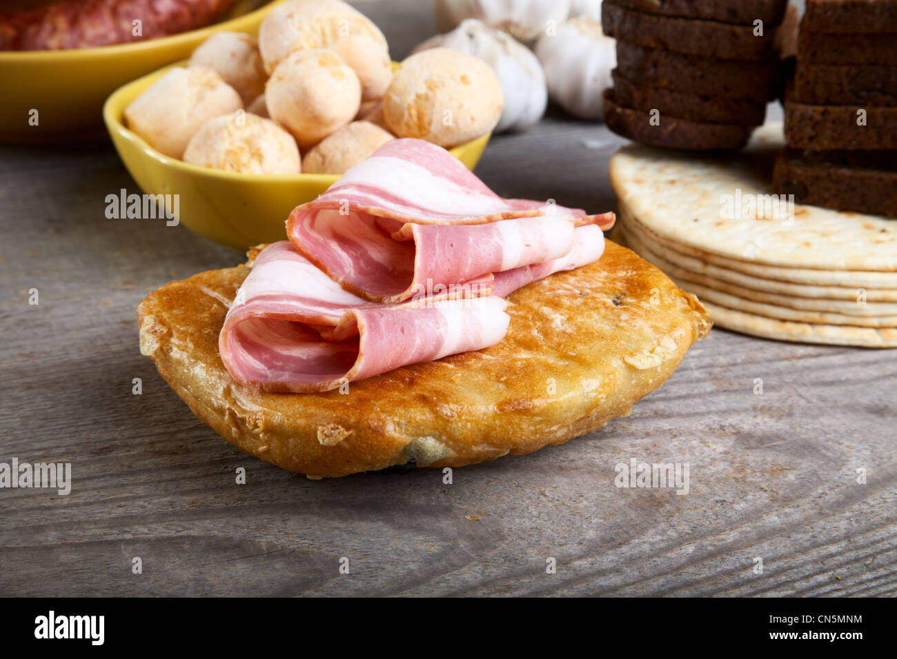 La nature morte avec du jambon et du pain sur une table en bois Photo