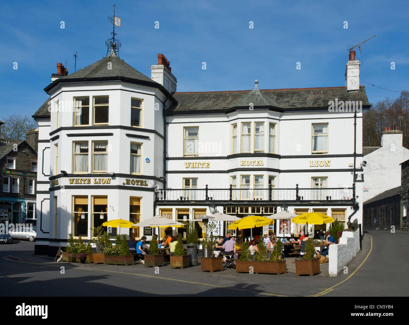 Les personnes qui boivent à l'extérieur de l'Hôtel White Lion, dans la ville de Ambleside, Parc National de Lake District, Cumbria, Angleterre, Royaume-Uni Banque D'Images