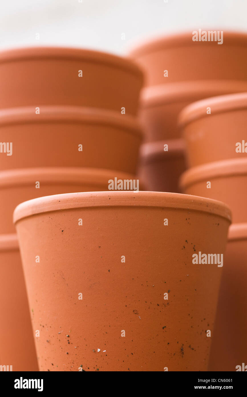 Une pile de pots dans le jardin contre un mur blanc. Banque D'Images