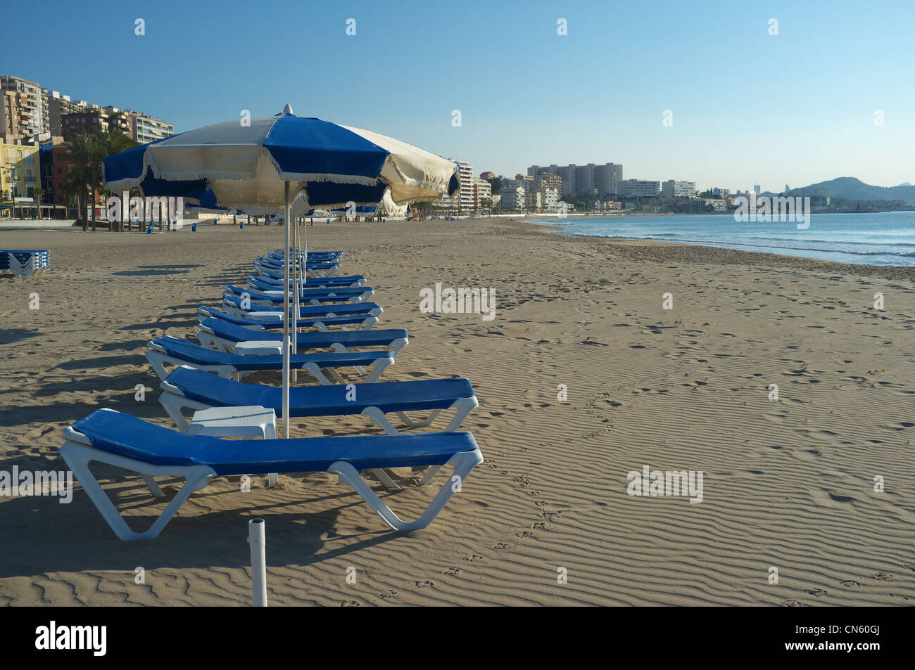 Chaises longues sur une plage de la Méditerranée, prêt pour l'été Banque D'Images