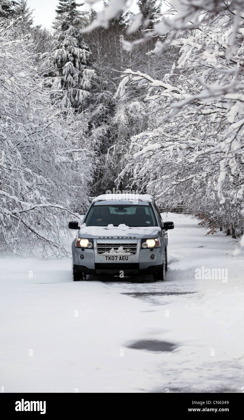 Land Rover Freelander 2 voyageant le long des routes rurales couvertes de neige en Ecosse, Royaume-Uni Banque D'Images