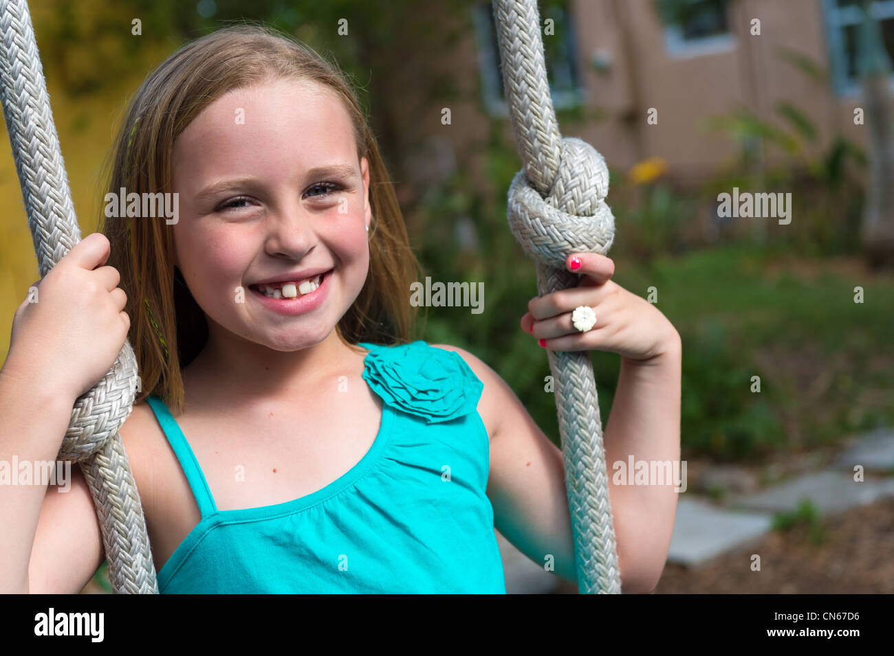 8 ans caucasian girl swinging dans l'arrière-cour Banque D'Images