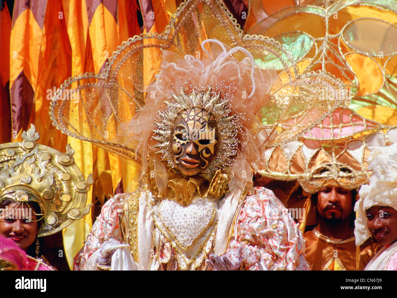 Danseurs portant des costumes de carnaval traditionnel dans des tons pastel et d'or à Trinidad, Caraïbes Banque D'Images