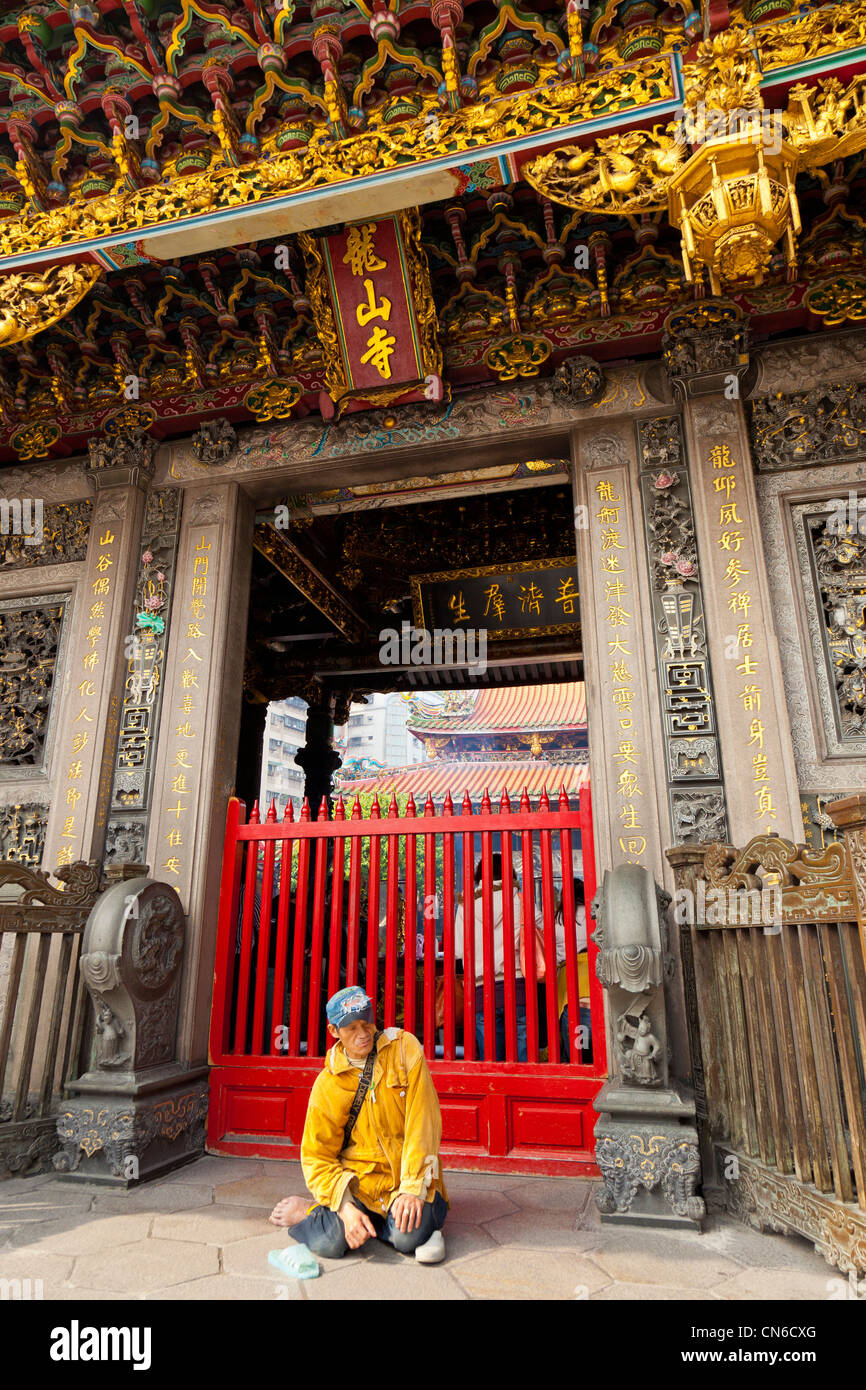Mendiant aux portes du temple de Longshan Lungshan ou Taipei Taiwan. JMH5687 Banque D'Images