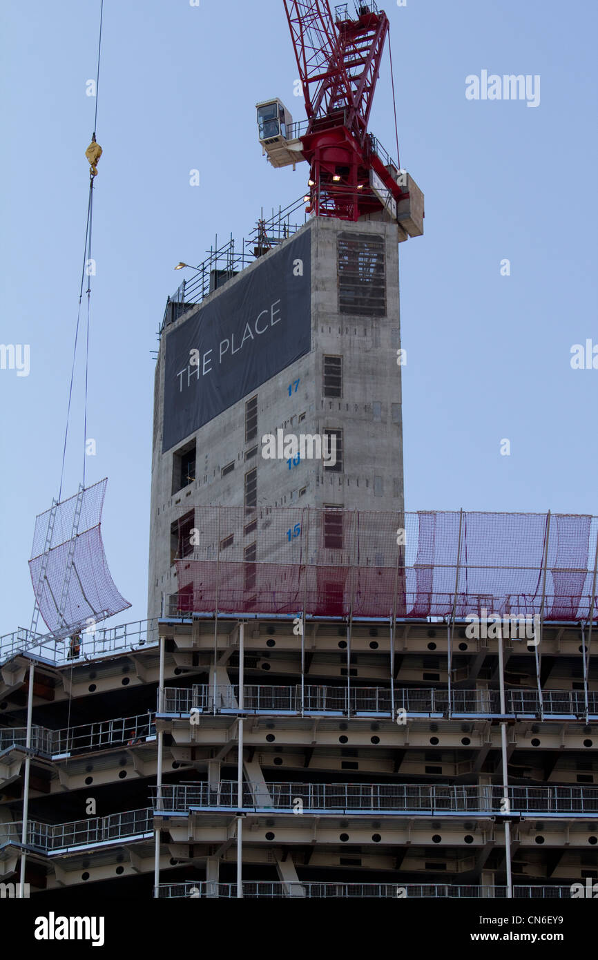 La construction en béton progresse à l’endroit près du Shard, remodelant la skyline de Londres, avec une grue sur le toit contre le ciel. Banque D'Images