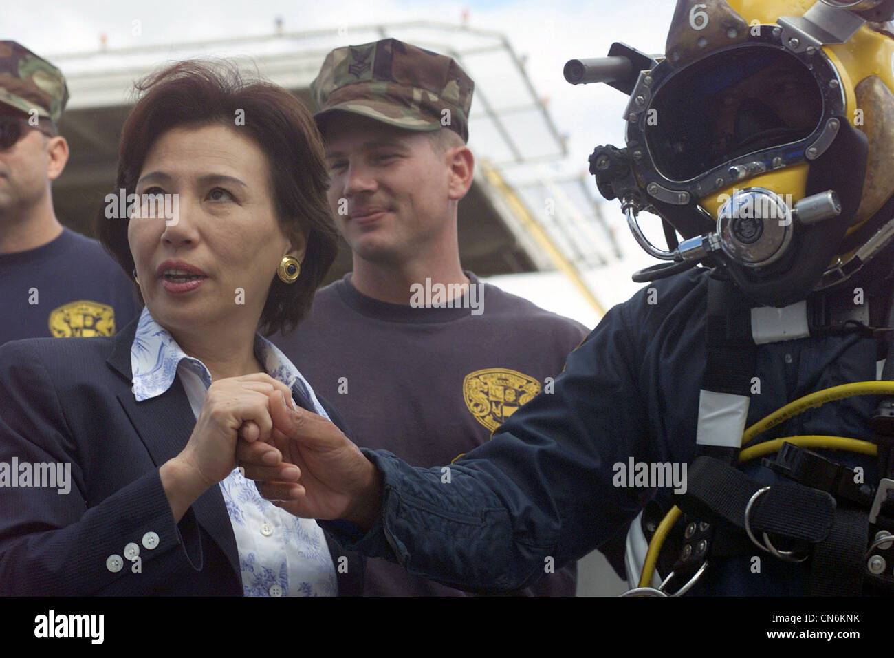 Son Excellence Makiko Tanaka, Ministre des Affaires étrangères du Japon, se met entre les mains du chef Boatswain’s Mate (BMC) de la Marine américaine (USN), Diver (DV) Robert Lastimosa, de l’unité mobile de plongée et de récupération One (MDSU-1) après avoir reçu une pièce de plongée de la Marine. Mme Tanaka est venue prêter son appui et a reçu une mise à jour sur l'effort mené par le USN pendant les opérations de rétablissement du navire de pêche japonais Ehime Maru. Banque D'Images