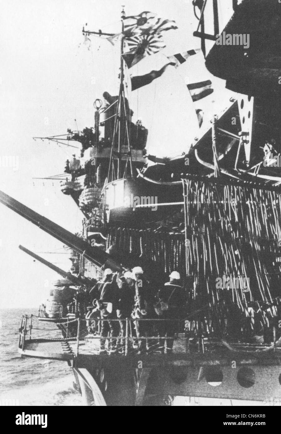 Un équipage de canon a son arme à bord du porte-avions de la Marine impériale japonaise Akagi. Il s'agit d'une position de canon antiaérien double de 120 mm de calibre 45 montée du côté port du porte-avions. Notez que la position est trop basse pour lui permettre de tirer sur la plate-forme de vol. La photo a été prise en novembre ou décembre 1941 alors que le transporteur se dirigeait vers Hawaï pour l'attaque sur Pearl Harbor. Banque D'Images