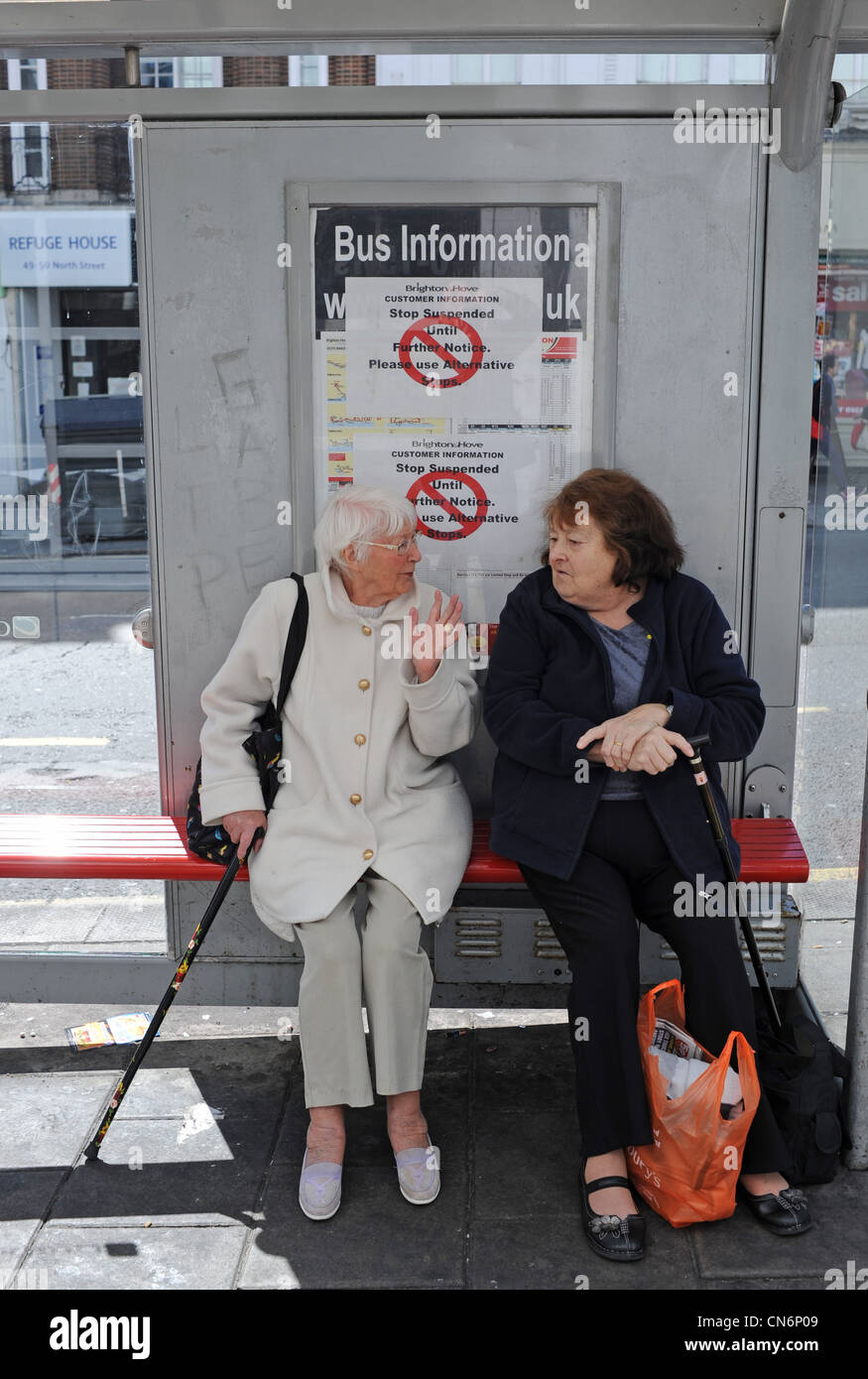 Le Brighton and Hove Bus Company informations inscription suspendue bus centre-ville UK avec 2 woman chatting ci-dessous Banque D'Images