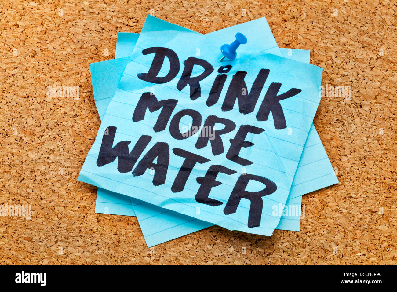 Boire plus d'eau d'hydratation - rappel - écriture sur blue note adhésive posté sur le panneau de liège Banque D'Images