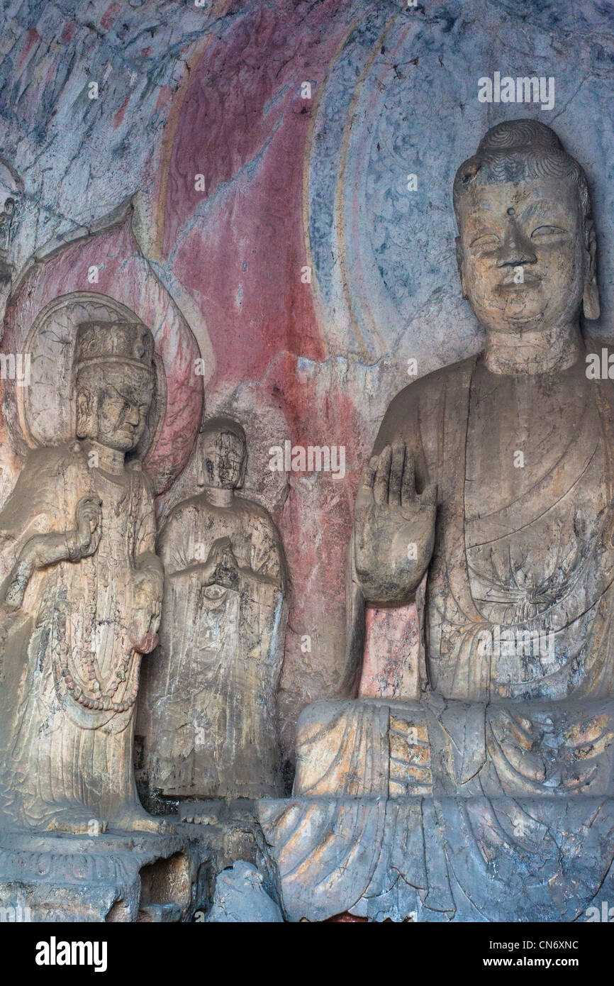 Sculptures en pierre de Bouddha et ses disciples au milieu grotte Binyang dans les grottes de Longmen site en Chine Banque D'Images