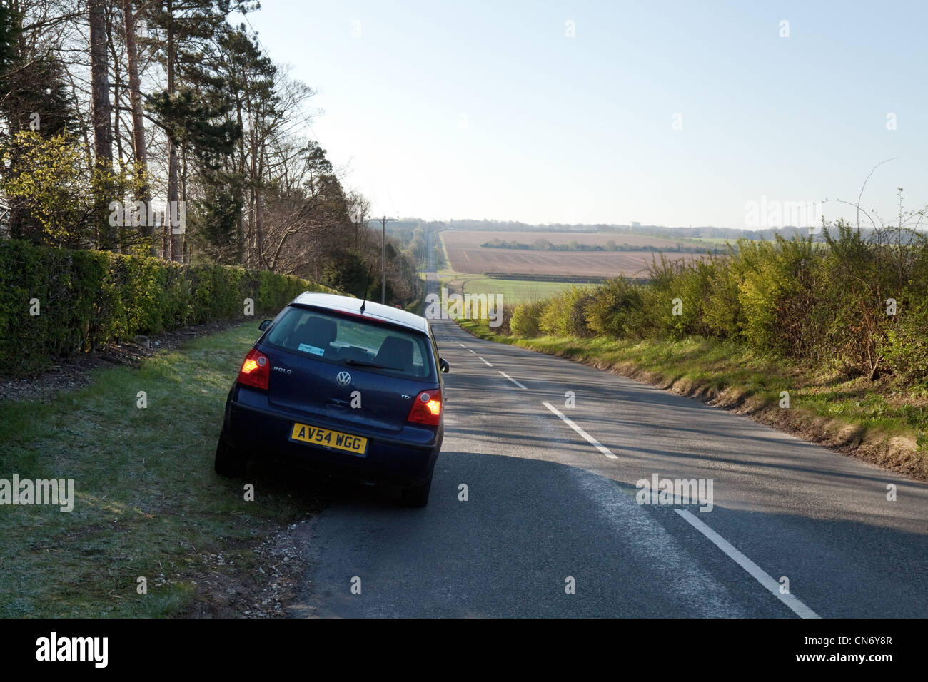 Une voiture garée sur le côté d'une route de campagne dans le Cambridgeshire East Anglia, Royaume-Uni Banque D'Images