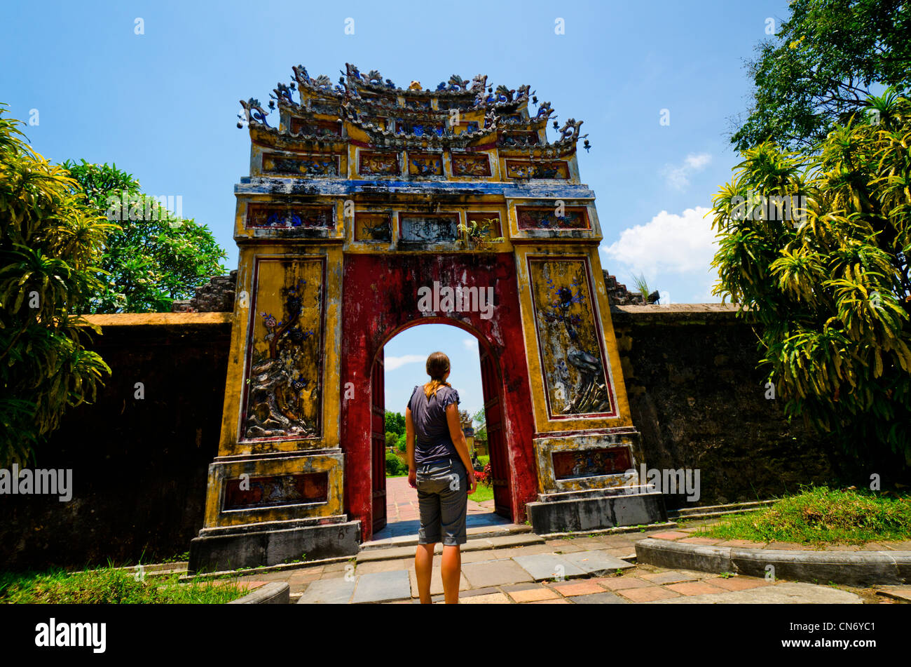 Les jeunes femmes à la recherche dans l'une des nombreuses portes qui entourent la Cité pourpre interdite, Site du patrimoine mondial de l'UNESCO, Hue, Vietnam Banque D'Images