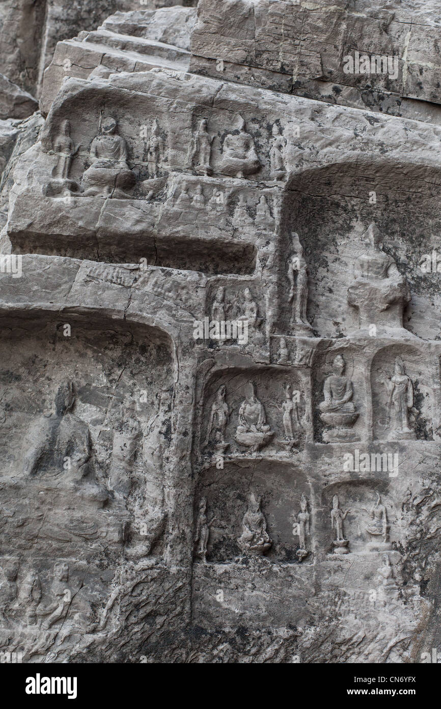 Sculptures en pierre de Bouddha et ses disciples au milieu grotte Binyang dans les grottes de Longmen site en Chine Banque D'Images