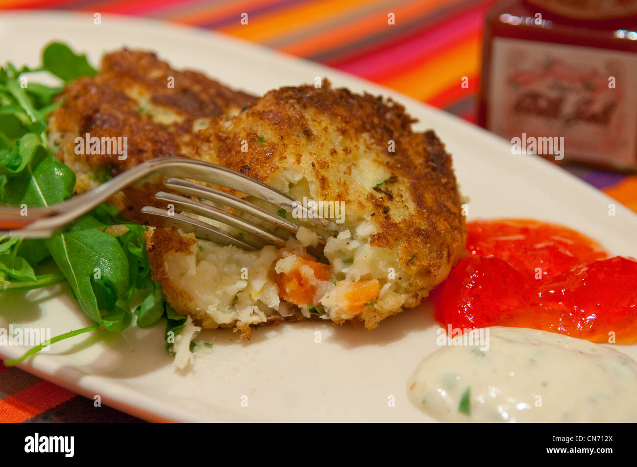 La coriandre et Lime fishcakes sur une plaque blanche Banque D'Images