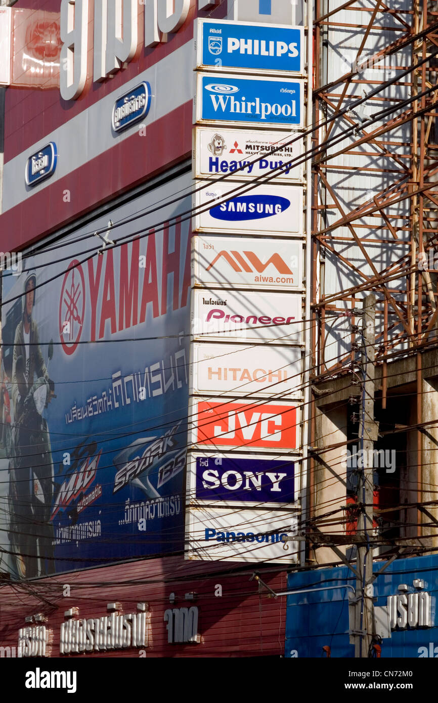 De nombreux signes publicité diverses marques font partie du paysage urbain au-dessus d'une rue de ville de Chiang Rai, Thaïlande. Banque D'Images