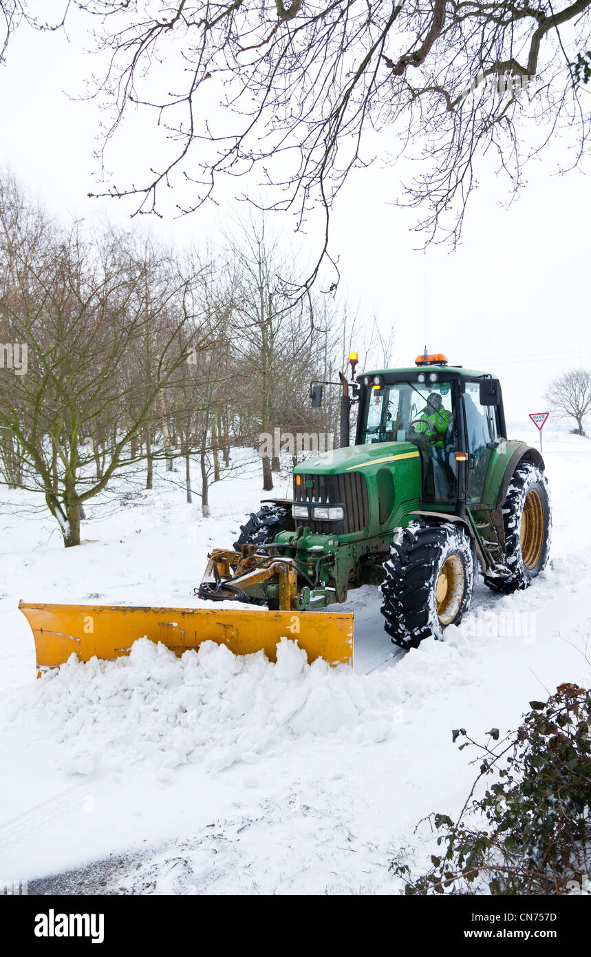 Un tracteur, monté avec un chasse-neige, le déneigement d'une route de  campagne Photo Stock - Alamy
