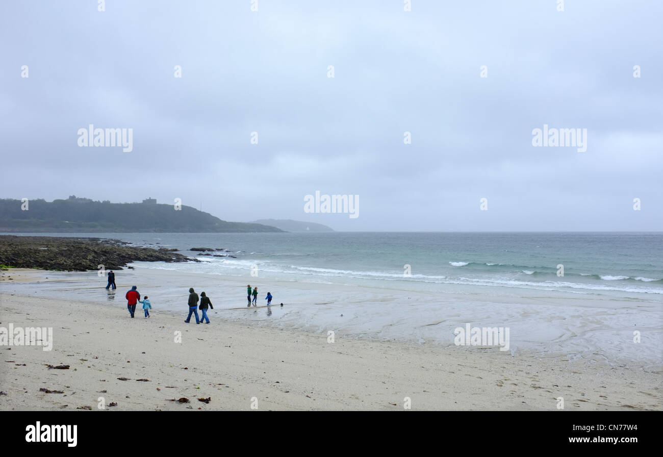 Une famille sur la plage Gyllyngvase à Cornwall à l'état humide et venteux jour Banque D'Images