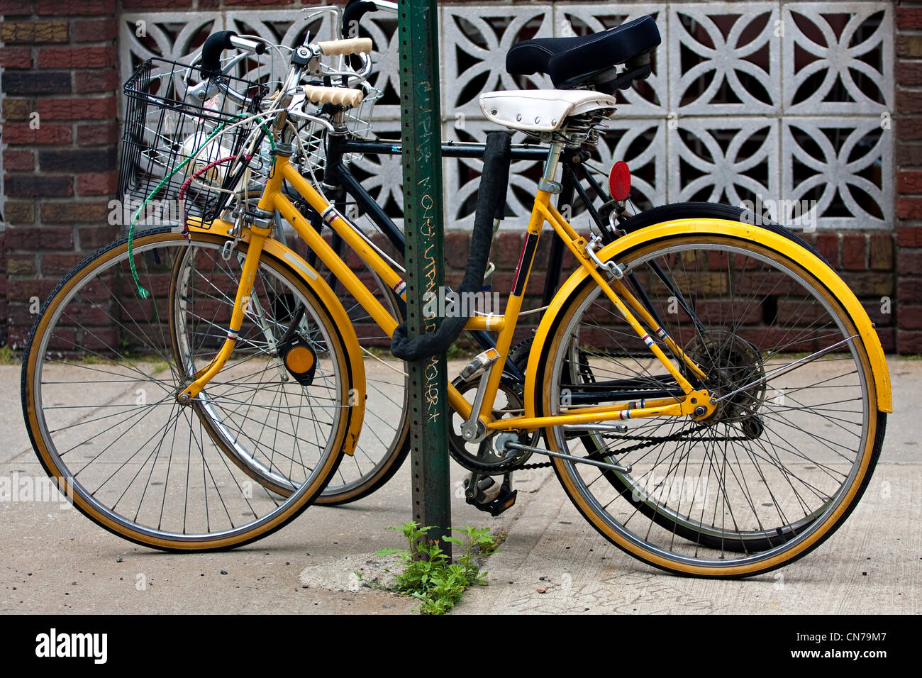 Un couple de bicyclettes enchaîné à un poteau dans la ville. Banque D'Images