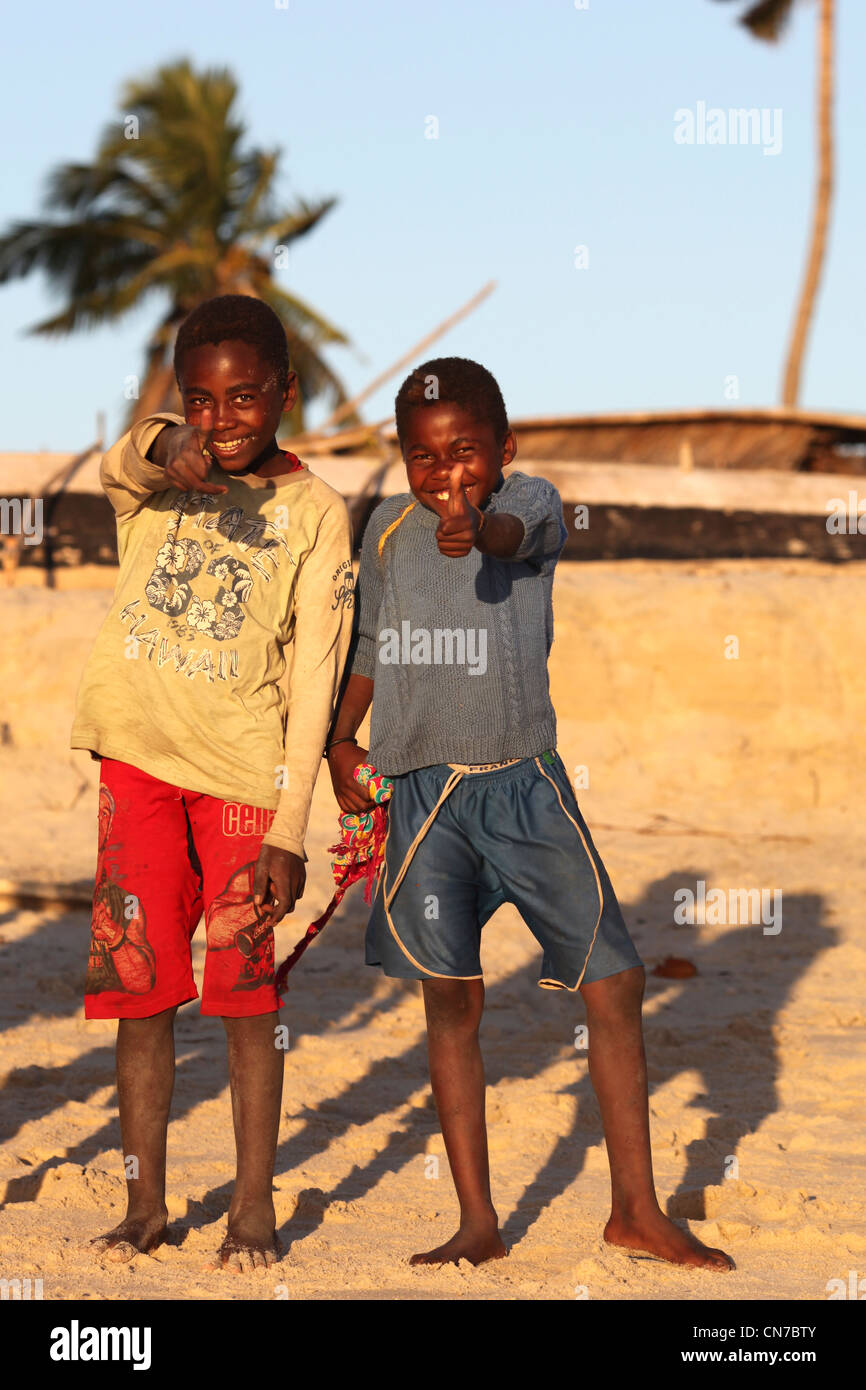 Deux garçons africains malgaches de l'ethnie Vezo donner le feu vert à un typique village de pêcheurs Vezo à distance et Banque D'Images