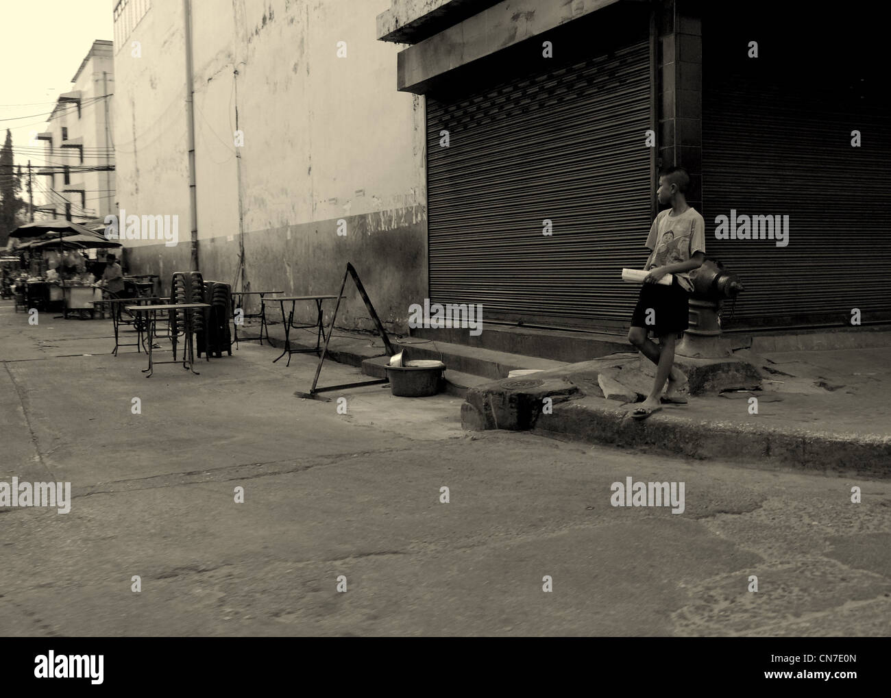 Jeune garçon debout sur coin de rue, de la rue à Bangkok, Bangkok, Thaïlande Banque D'Images