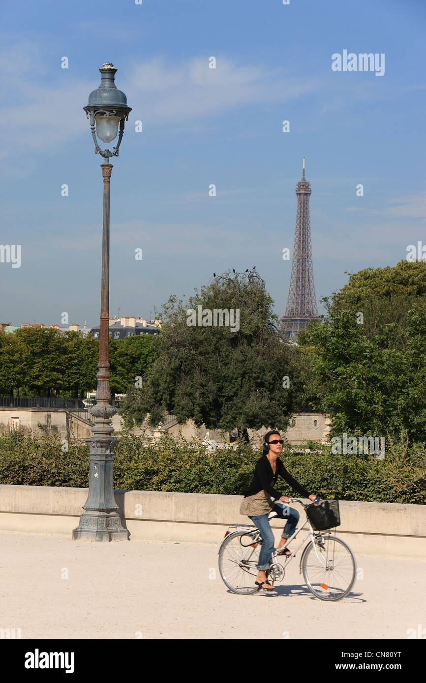 France, Paris, des femmes de rouler à vélo dans les jardins des Tuileries et La Tour Eiffel en arrière-plan Banque D'Images