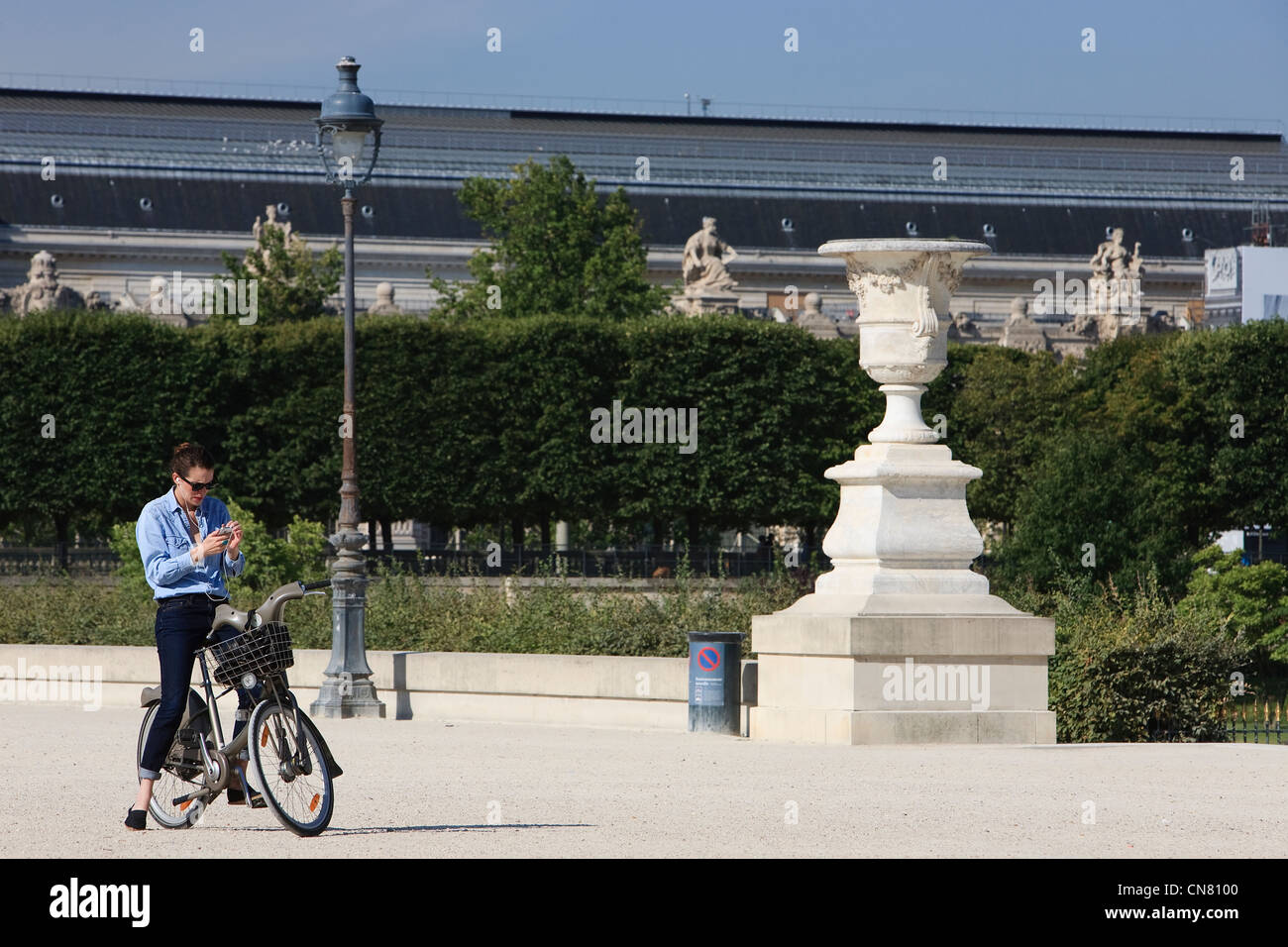 France, Paris, des femmes de rouler à vélo dans les jardins des Tuileries Banque D'Images