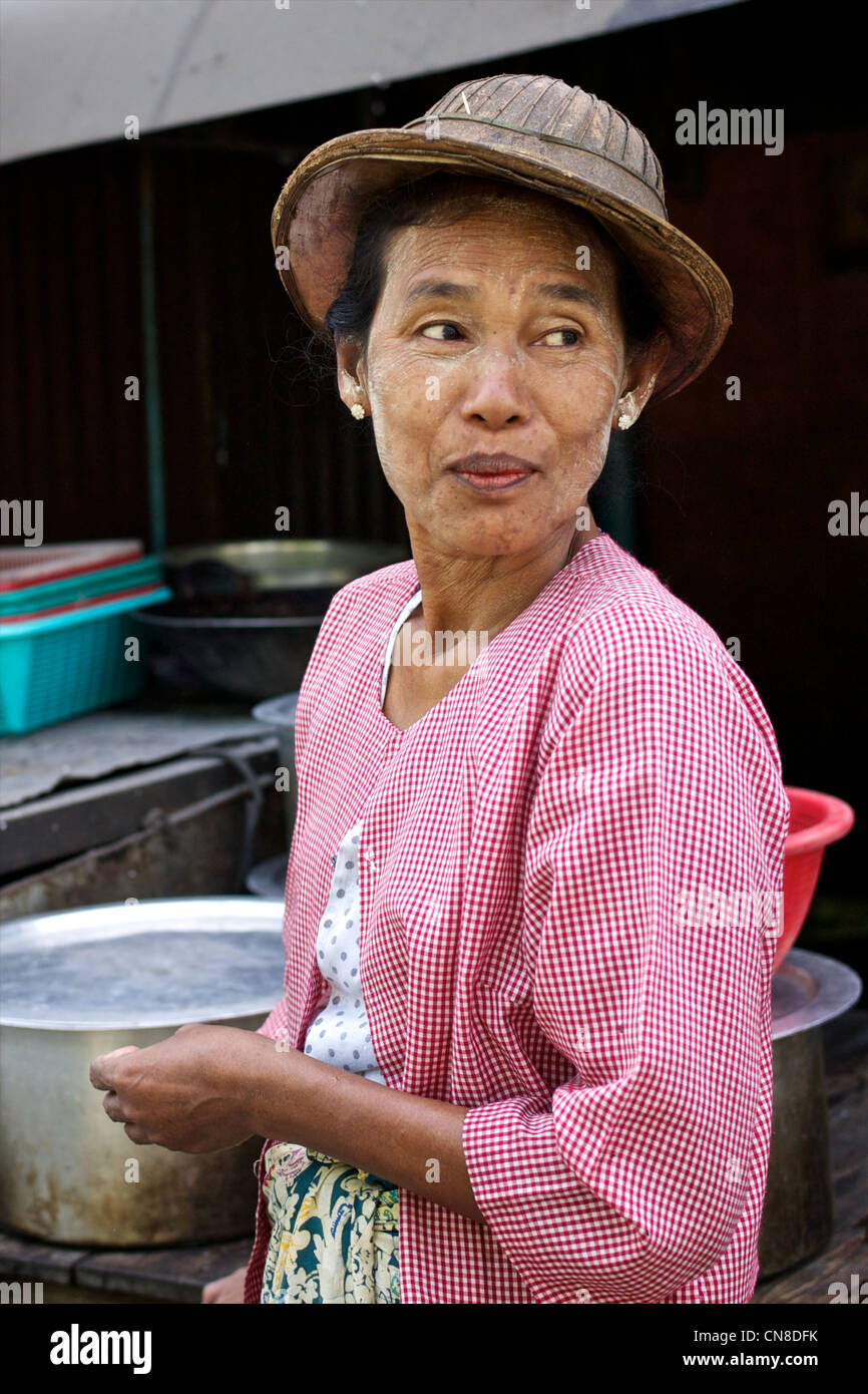 Street portrait de femme birmane en bambou traditionnel chapeau et portant thanaka cosmétique visage Banque D'Images