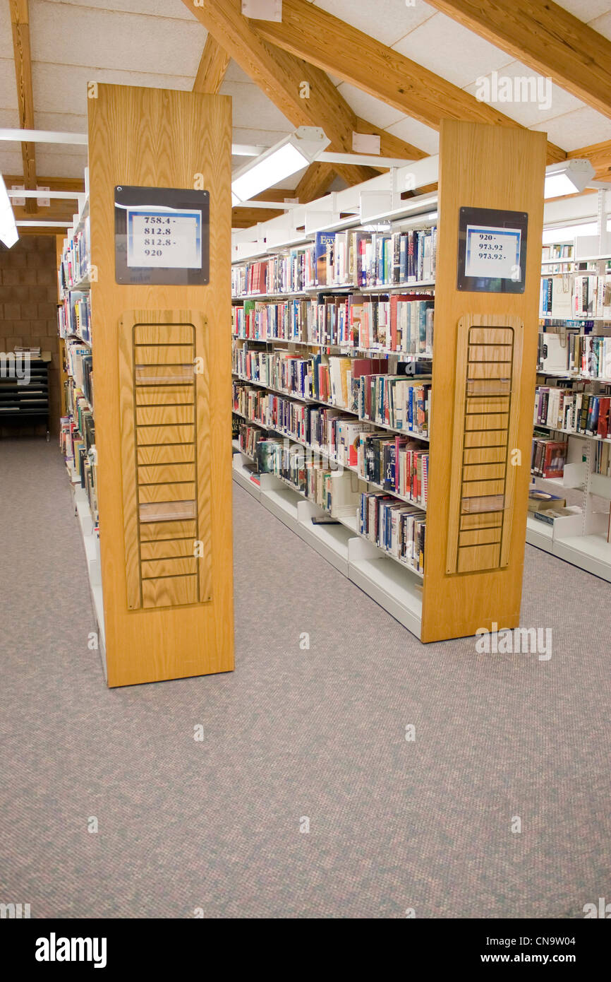 Les allées dans une bibliothèque publique avec des étagères pleines de livres. Banque D'Images
