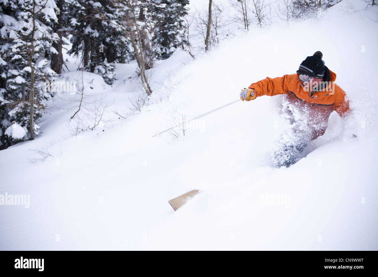 La pulvérisation de skieur sur une pente de neige Banque D'Images