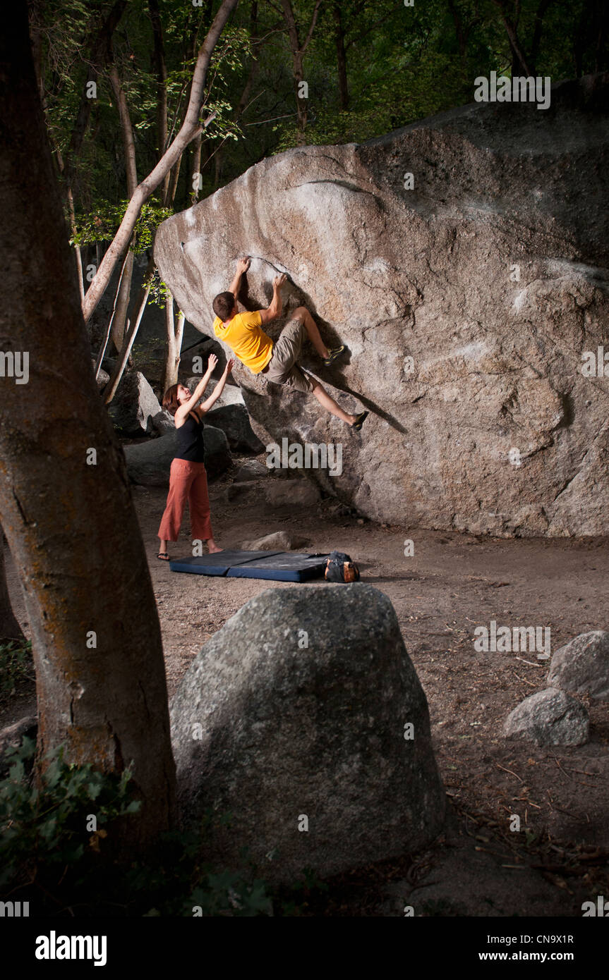 Grimpeurs scaling boulder face Banque D'Images