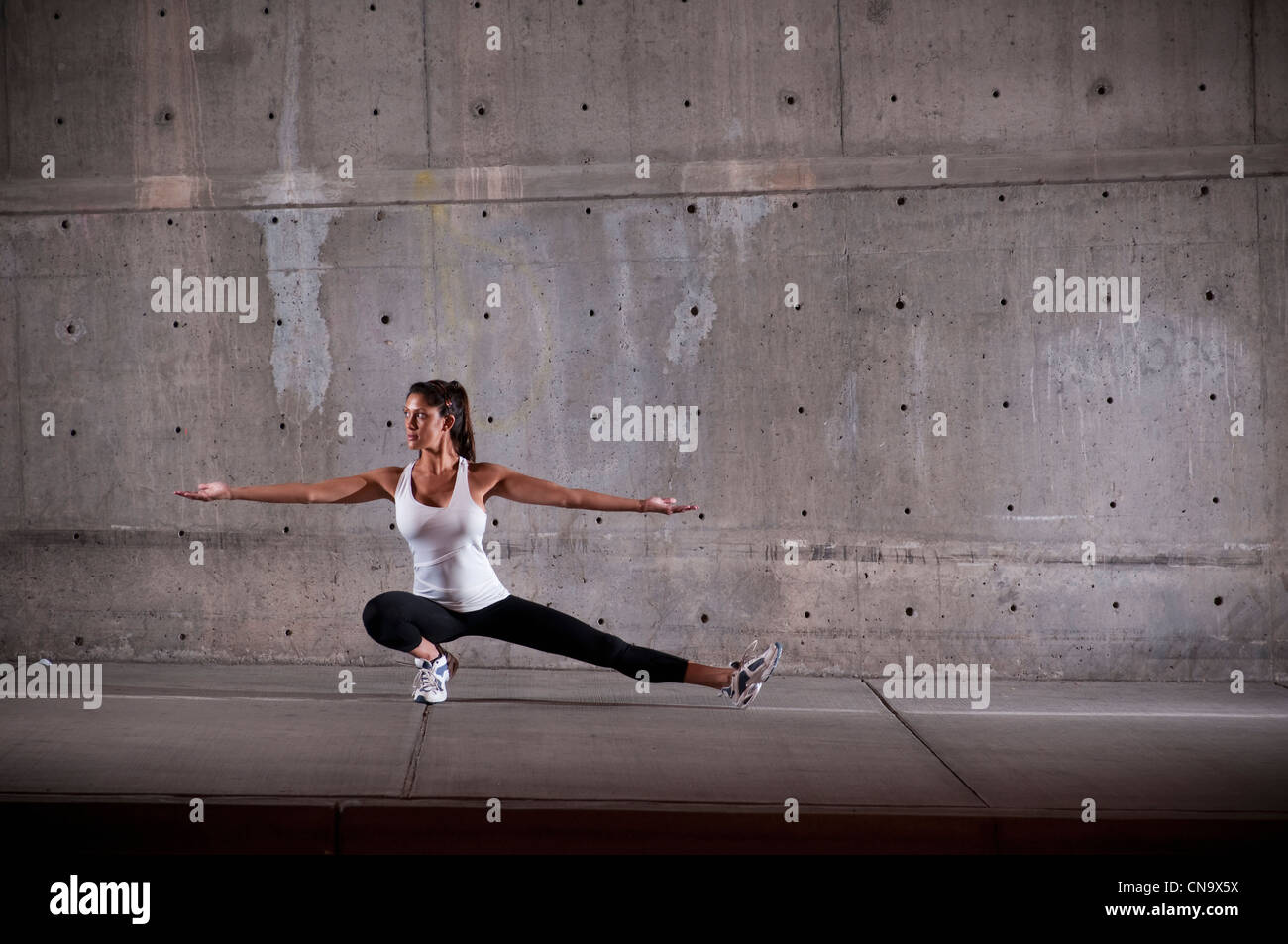 Runner stretching on sidewalk Banque D'Images