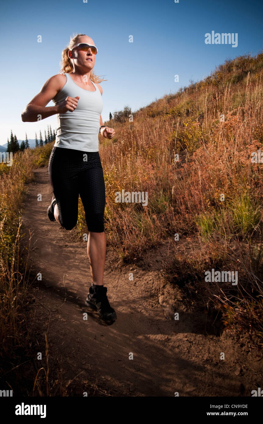 Woman running on dirt path Banque D'Images