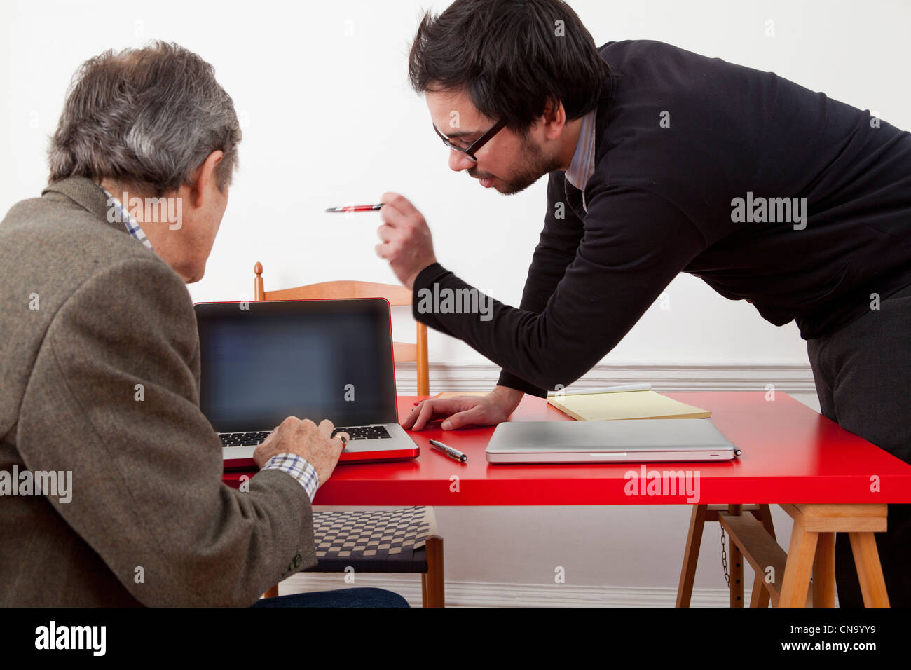 Hommes d'working together on laptop Banque D'Images