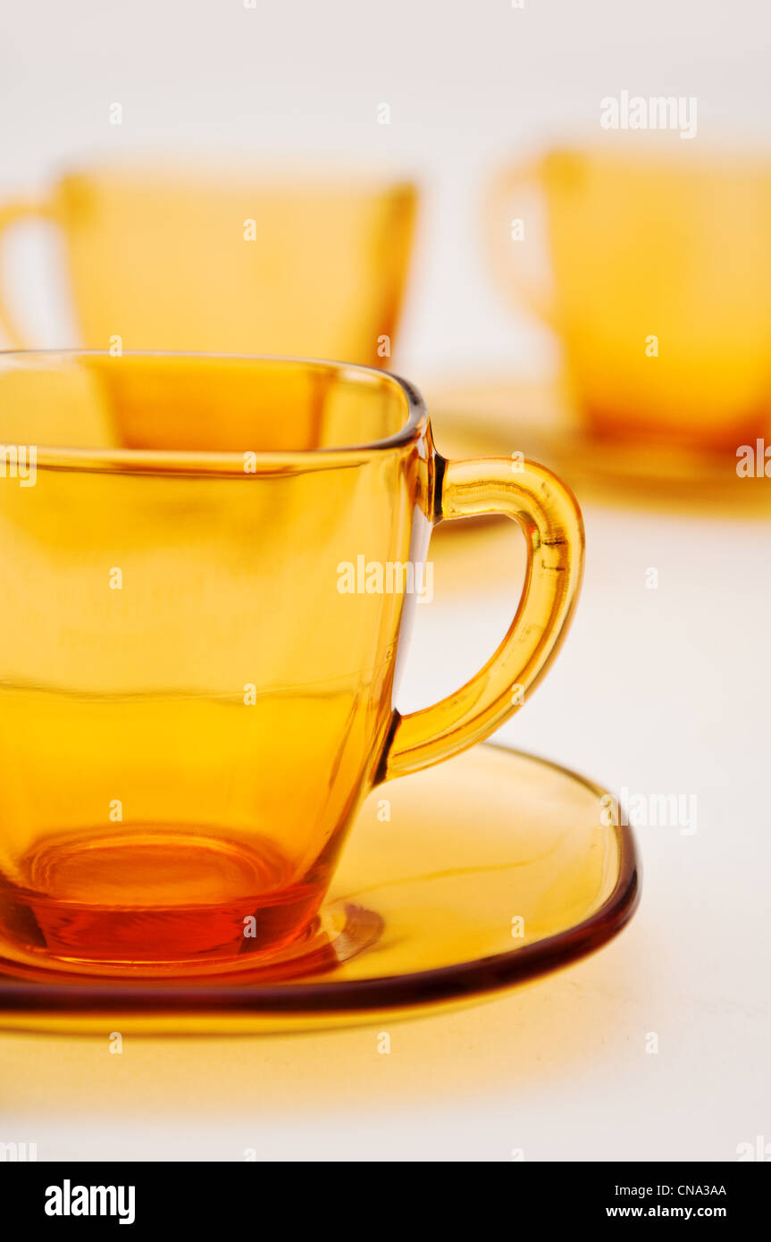 Tasses à thé en verre jaune contre le fond blanc Banque D'Images