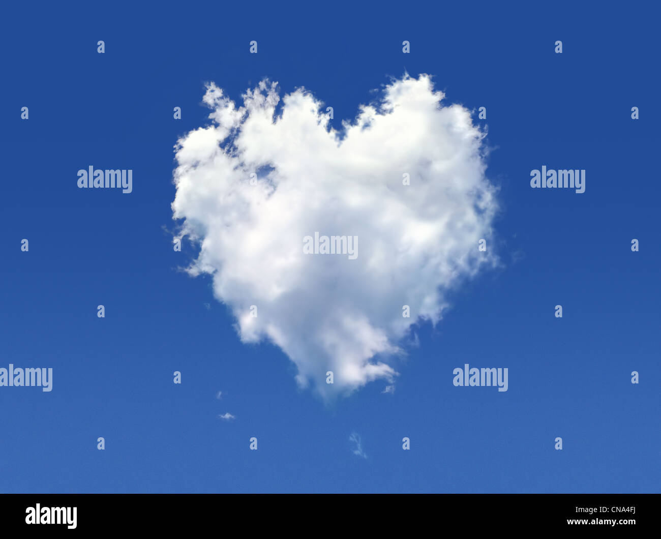 Nuage moelleux de la forme de coeur, sur un ciel bleu profond. Banque D'Images