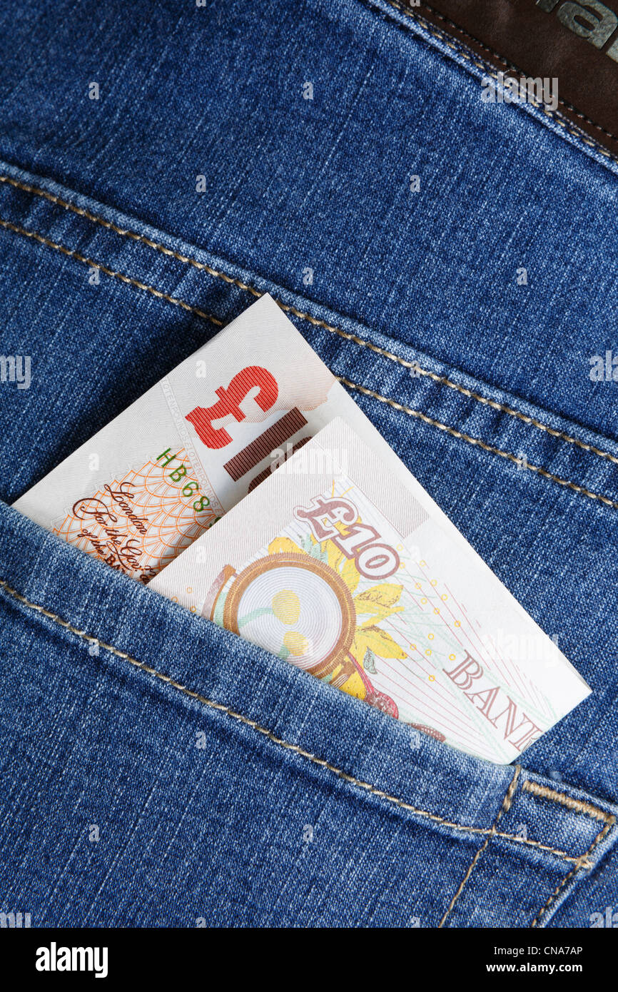 Dix livres sterling argent note en liquide dans une poche arrière, d'une paire de jeans bleu pour illustrer un concept de vie. Angleterre Royaume-uni Grande-Bretagne Banque D'Images