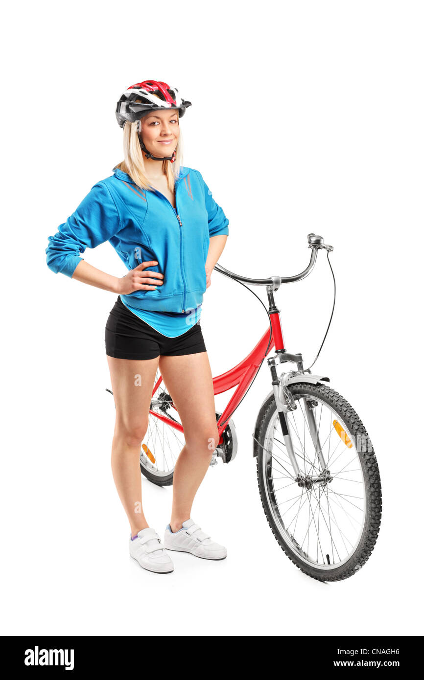 Portrait d'une femme motard avec casque posant à côté d'un vélo isolé sur fond blanc Banque D'Images