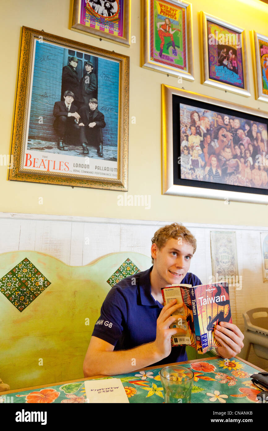 Touristiques de l'Ouest lecture guide Lonely Planet à Taïwan en restaurant à Kaohsiung Taiwan. JMH5961 Banque D'Images