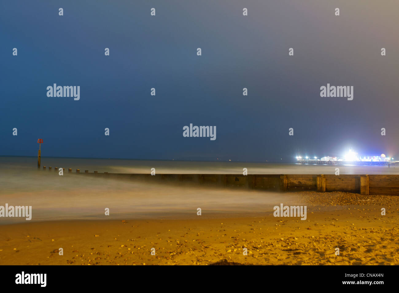 Matériel roulant dans les vagues sur la plage au soir Banque D'Images