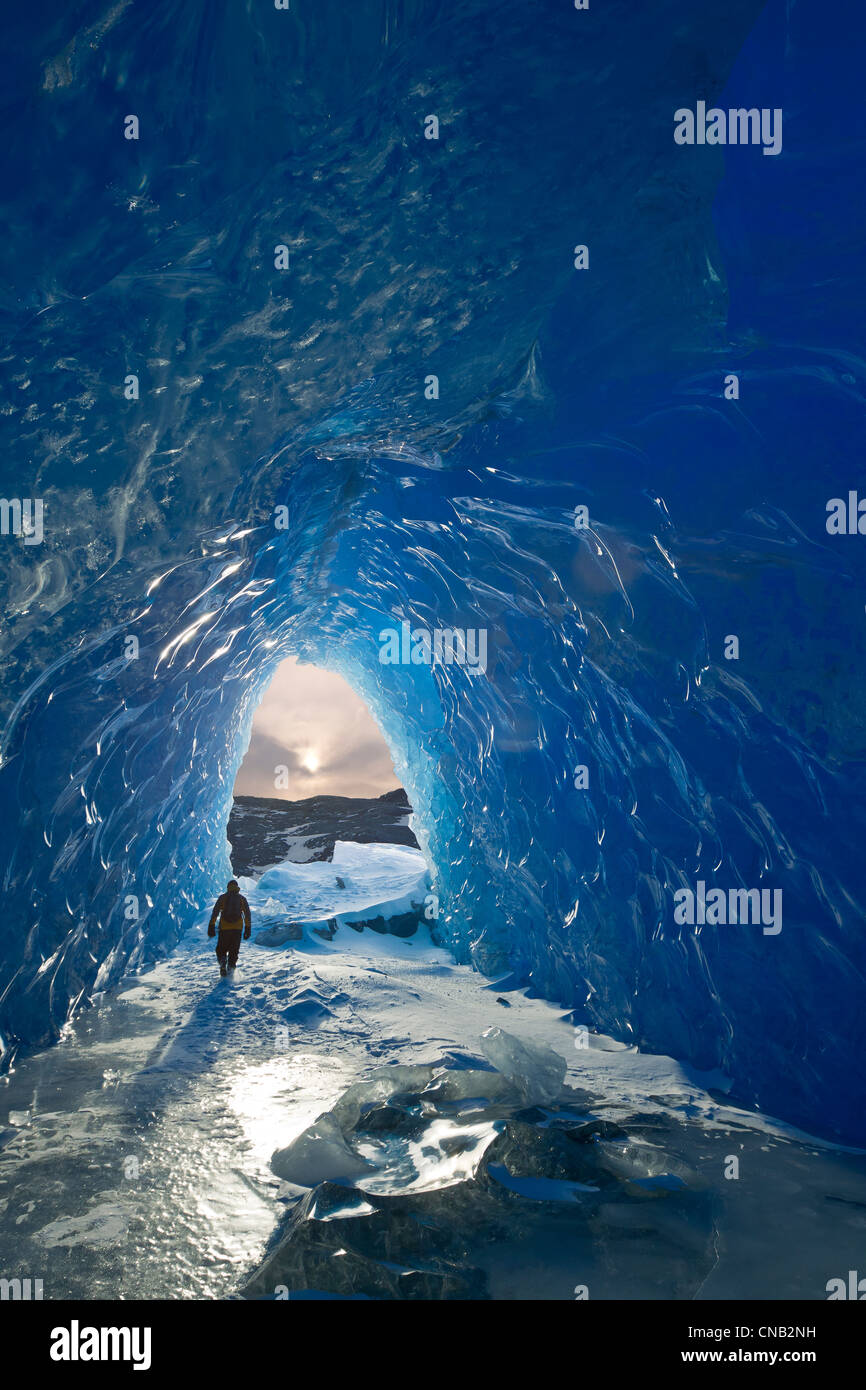 Homme marche à l'intérieur d'une grotte de glace d'un iceberg dans le lac gelé de Mendenhall, Juneau, Alaska du Sud-Est, l'hiver Banque D'Images