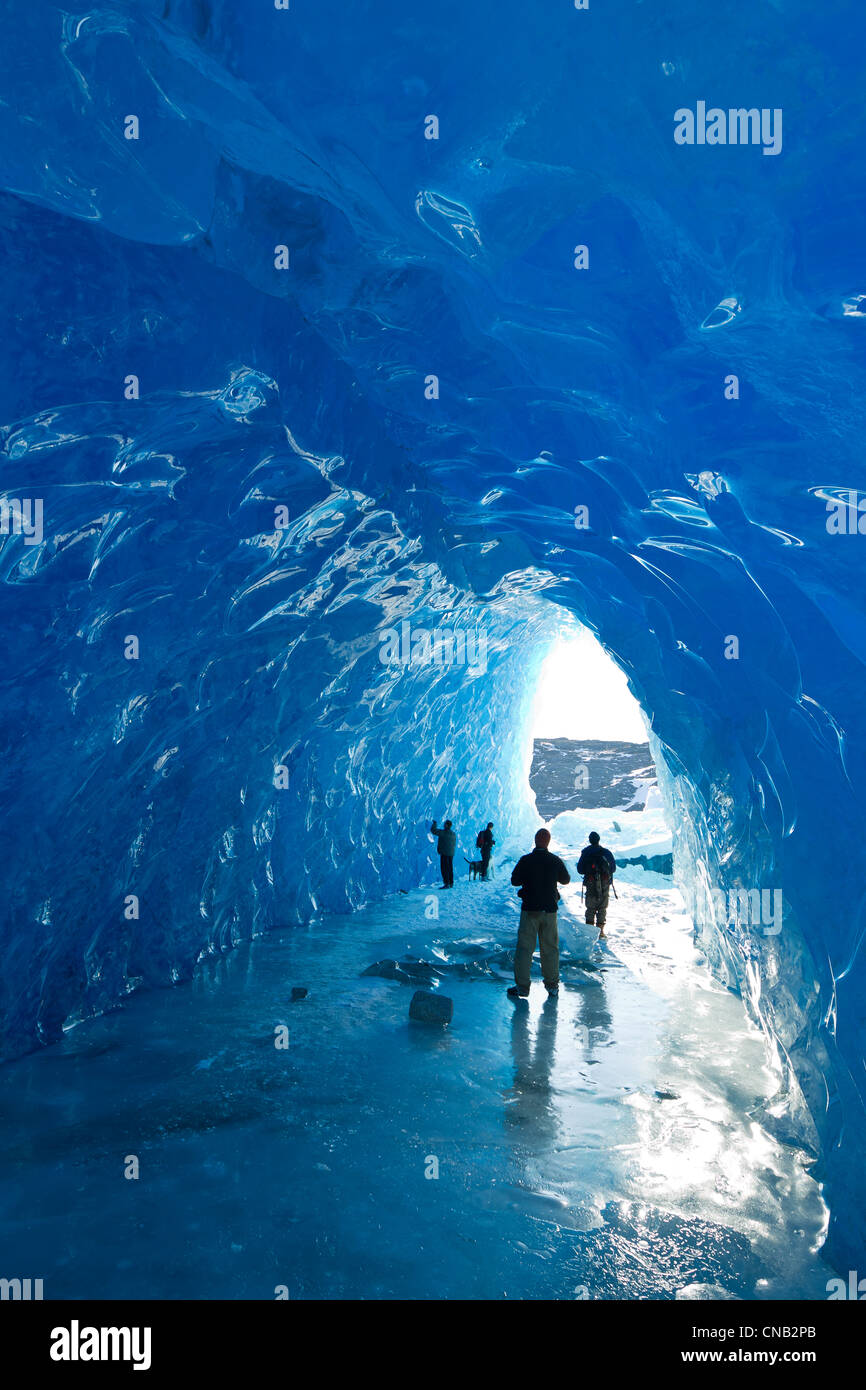 Groupe de personnes à l'intérieur d'une grotte de glace d'un iceberg dans le lac gelé de Mendenhall, Juneau, Alaska du Sud-Est, l'hiver Banque D'Images