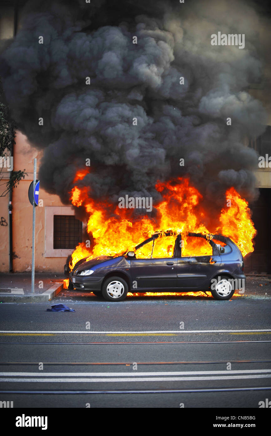 Des émeutes dans la rue, location hors de contrôle. Le véhicule est enveloppé dans des incendies et la fumée de la tenture qui rend impossible d'éteindre les flammes. Banque D'Images