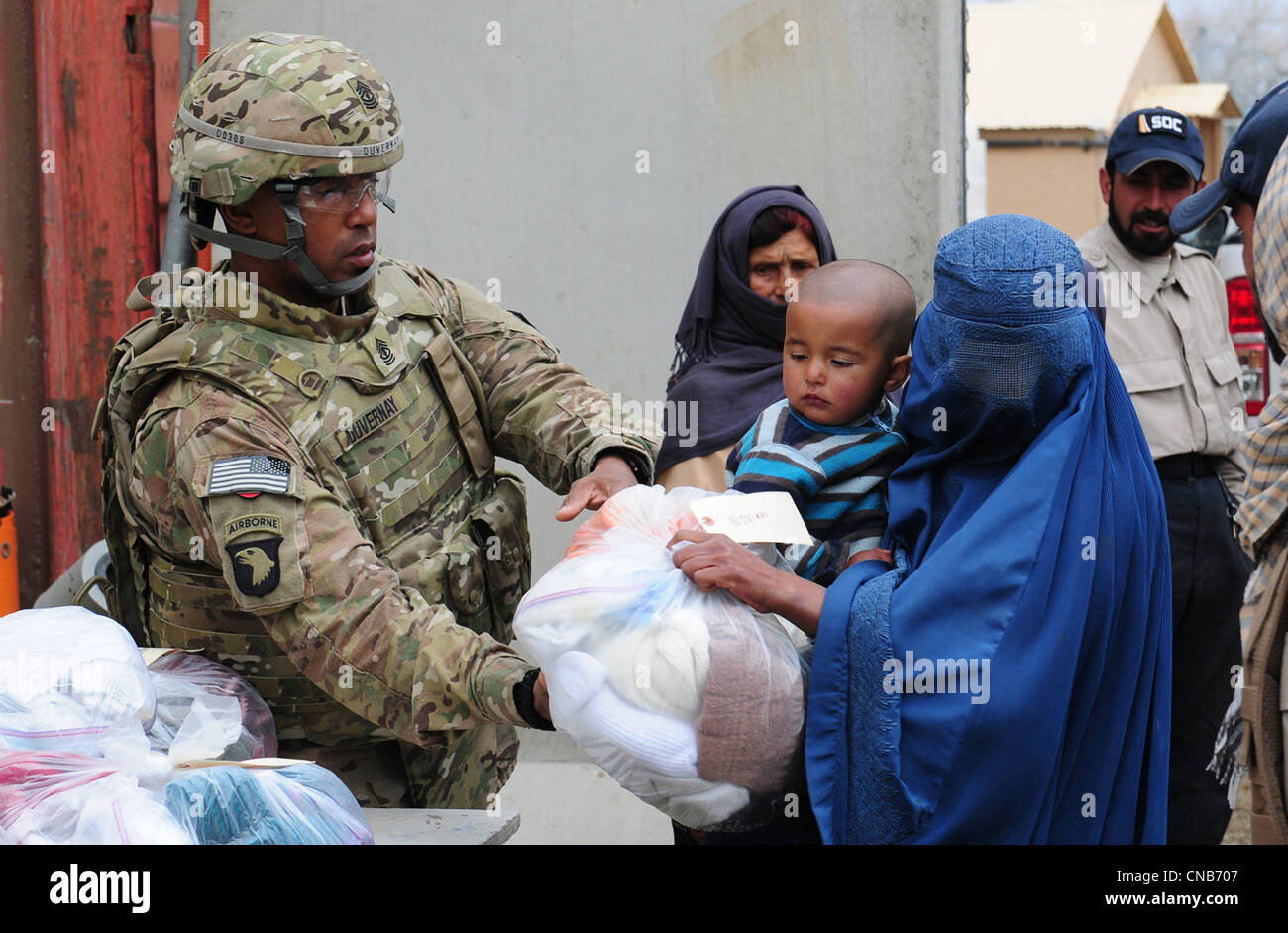 Soldat de l'armée américaine Herbert Duvernay distribue des vêtements à une femme afghane portant un corps plein burqa à El Salam hospial égyptien Banque D'Images