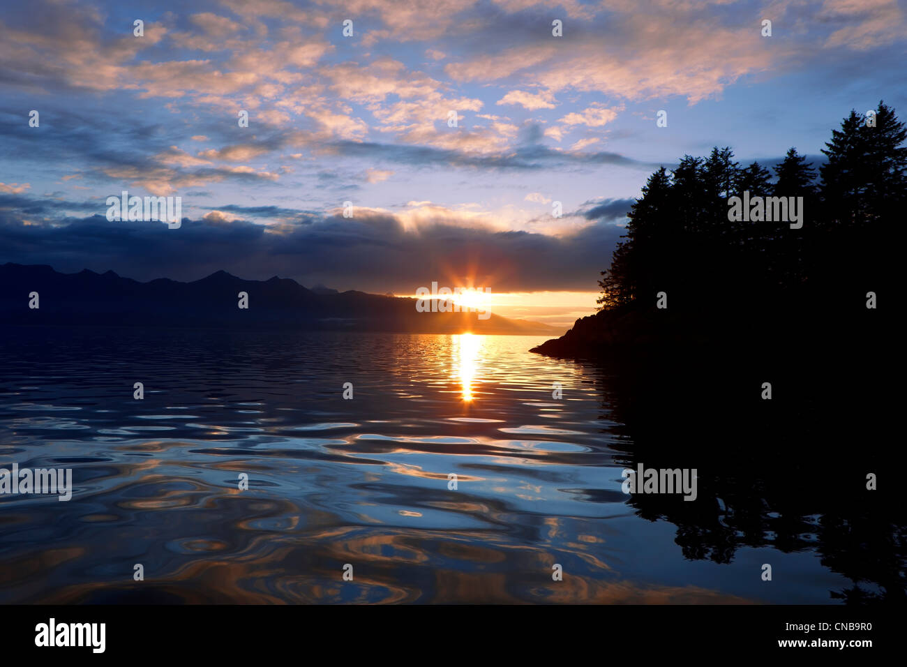 Le soleil se couche derrière l'île de l'Amirauté, passage Stephens, sud-est de l'Alaska, l'été Banque D'Images