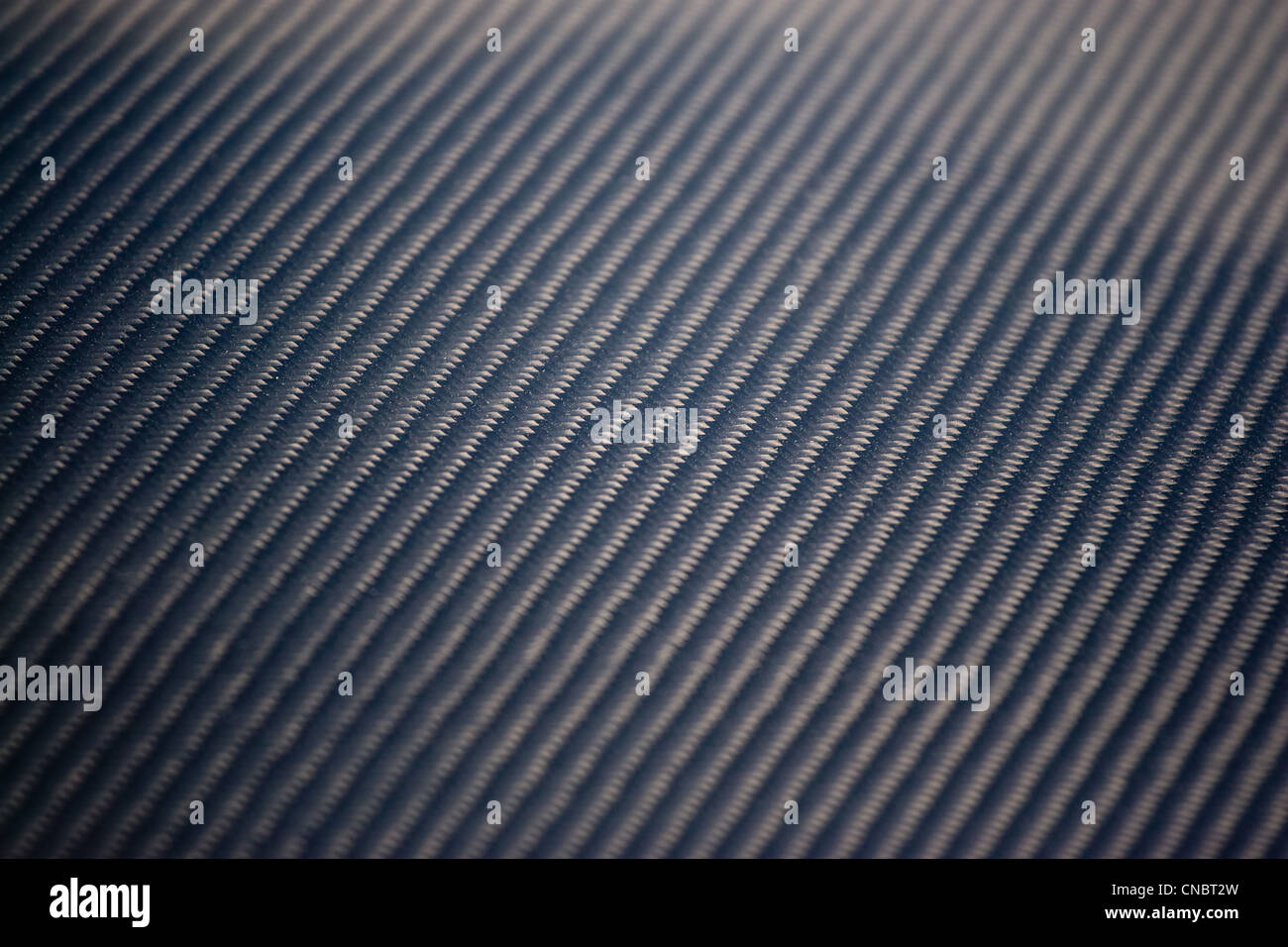 Un gros plan d'un matériau en fibre de carbone. Cela fait une excellente texture ou d'arrière-plan. Profondeur de champ. Banque D'Images