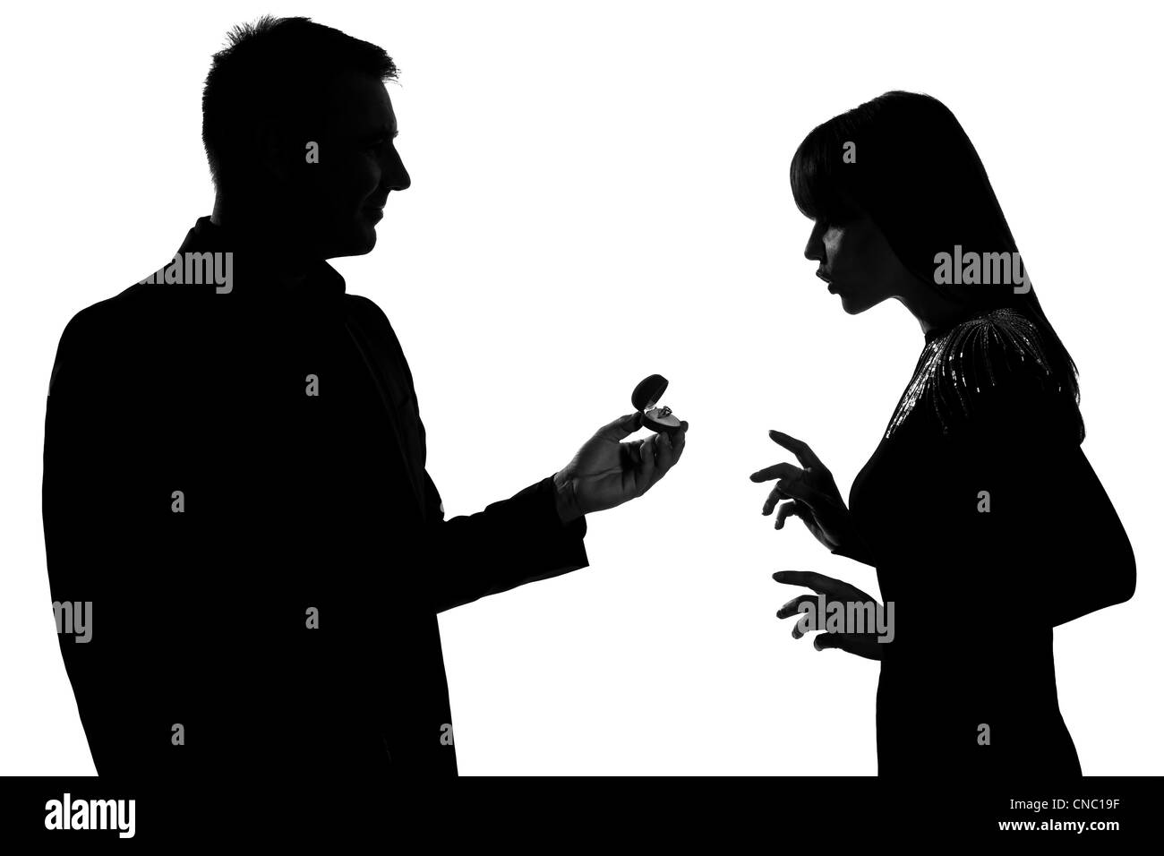 Un couple man bague de fiançailles et la femme surprise en silhouette studio isolé sur fond blanc Banque D'Images Un couple man bague de fiançailles et la femme surprise en silhouette studio isolé sur fond blanc Banque D'Images