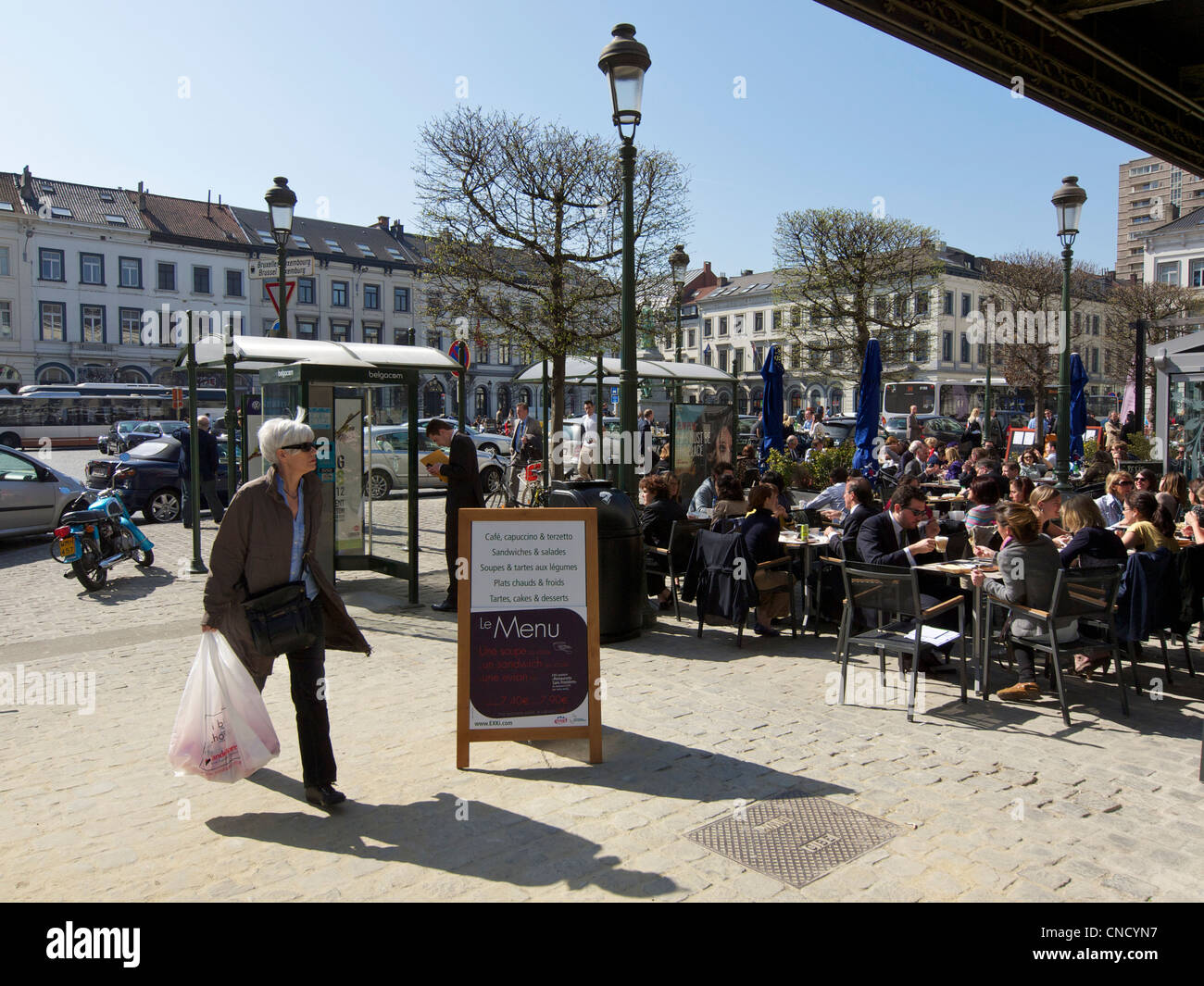 Beaucoup de gens profiter du soleil pendant leur pause déjeuner sur la Place du Luxembourg à Bruxelles, Belgique Banque D'Images