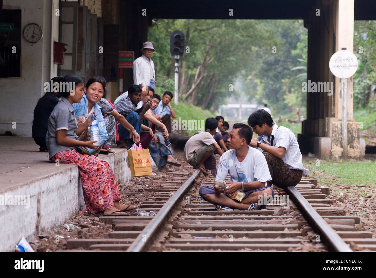 En attendant un train. Groupe de Birmans assis sur la ligne de chemin de fer dans la gare. Yangon, Myanmar 2006 2000s Asie du Sud-est. HOMER SYKES Banque D'Images