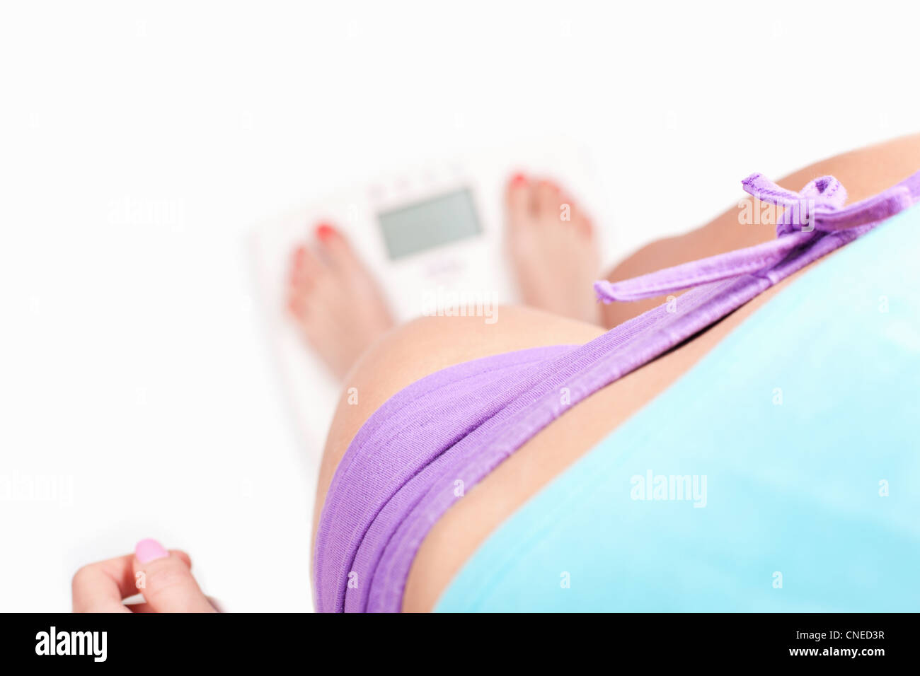 Cheking poids, fille debout sur l'échelle numérique - concept de régime, sur fond blanc Banque D'Images